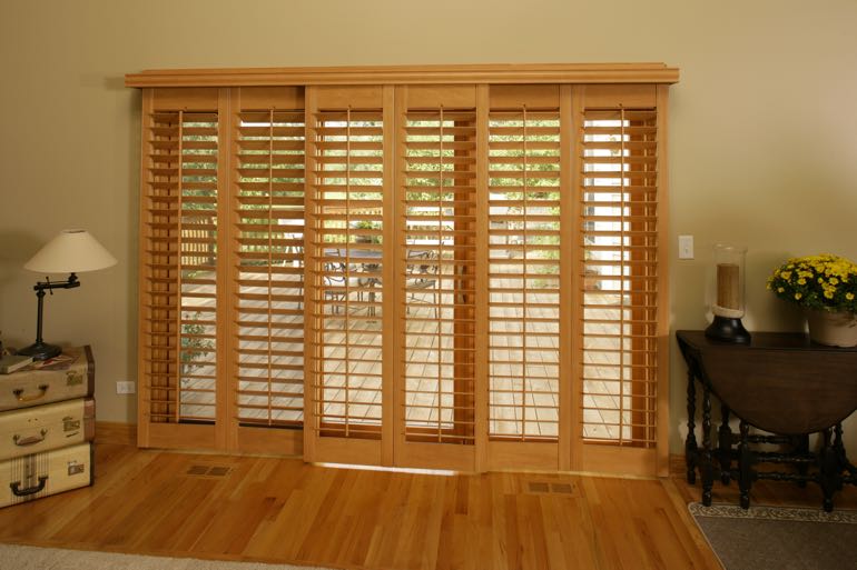 plantation shutters on sliding door connecting to back porch.